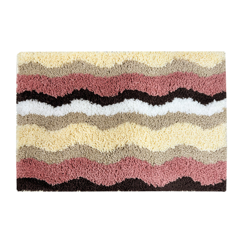 Rectangular bathroom rug with a wavy stripe pattern in pink, yellow, beige, brown, and white, featuring a soft and plush texture.