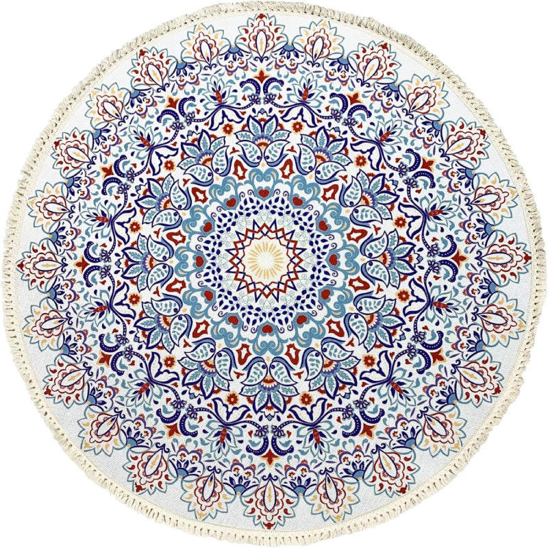 Round bohemian-style rug with an intricate mandala pattern in blue, terracotta, and gold, featuring floral and geometric motifs and finished with fringe tassels around the edge.