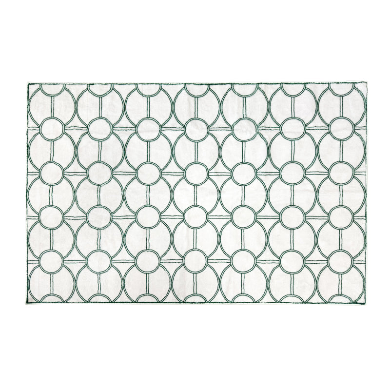 White summer rug with a modern green circular geometric pattern.