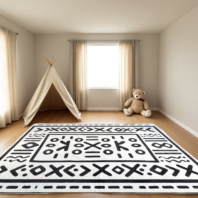 Geometric tribal-style rug with bold symbolic patterns laid in a bright, elegant living room setting.