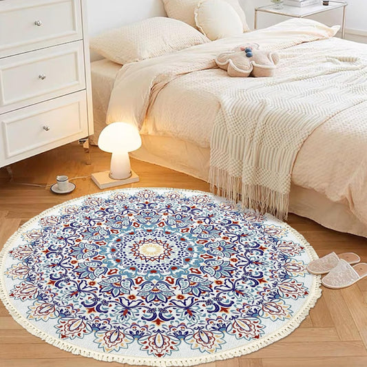 Round bohemian-style rug with an intricate mandala pattern in blue, terracotta, and gold, featuring floral and geometric motifs and finished with fringe tassels around the edge.