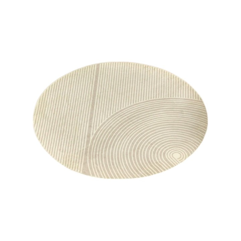 Round beige bathroom rug with a minimalist striped and curved line pattern, placed on a brown floor next to a bathtub, pink towel, and potted plants.