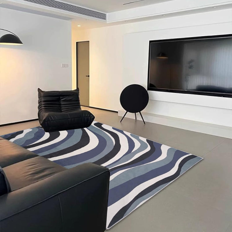 Laundry rug with abstract blue, black, and white wavy line pattern, modern design with a soft textured surface.