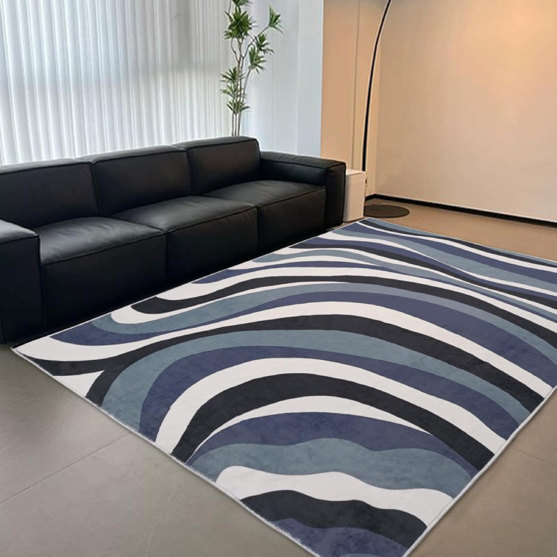 Laundry rug with abstract blue, black, and white wavy line pattern, modern design with a soft textured surface.