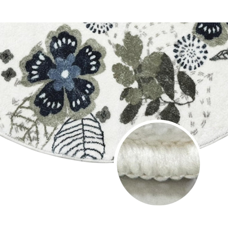 Round living room rug with blue and green floral pattern on an ivory background, placed in a cozy wooden interior with a rocking horse and storage cabinet.