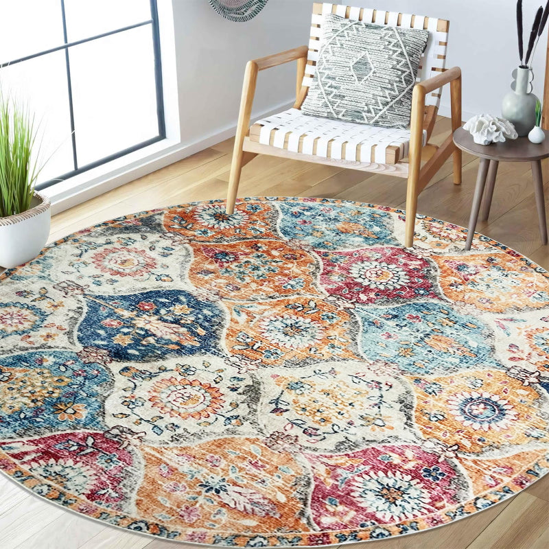 Round boho vintage area rug with a colorful patchwork of floral and medallion patterns in orange, blue, red, and cream tones.