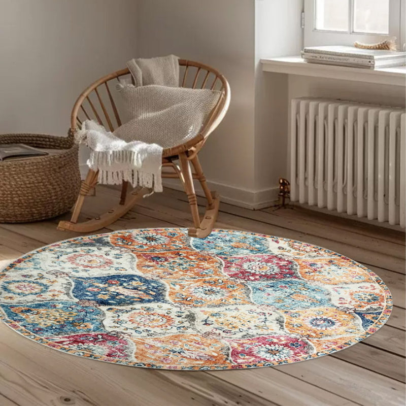 Round boho vintage area rug with a colorful patchwork of floral and medallion patterns in orange, blue, red, and cream tones.