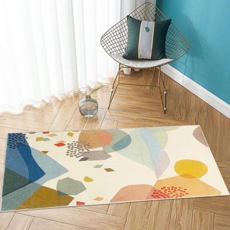 Kids rug with abstract colorful stone pattern in shades of blue, yellow, red, green, and beige on a cream background.