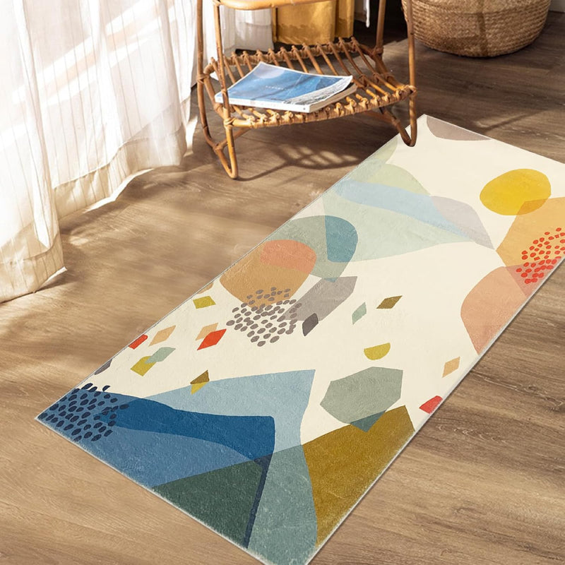 Kids rug with abstract colorful stone pattern in shades of blue, yellow, red, green, and beige on a cream background.