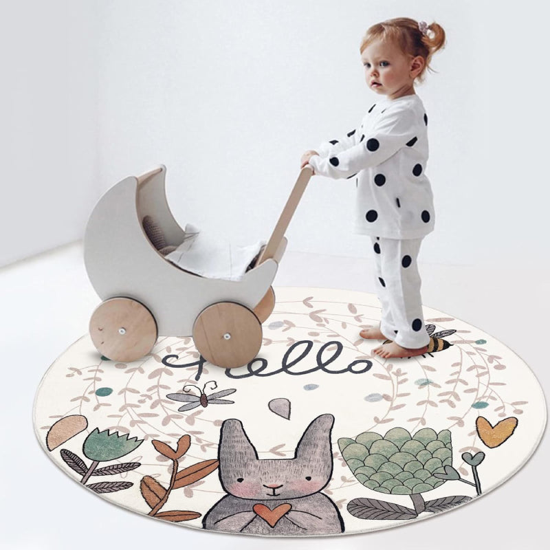Round children's rug featuring a cute gray Easter bunny holding a heart, surrounded by flowers, a bee, a butterfly, and the word "hello" in playful script on a light background.