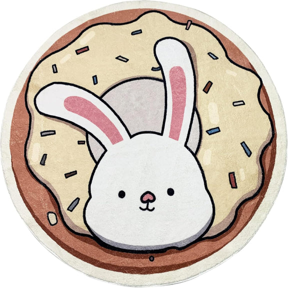 A round children's rug featuring a cute white bunny with pink ears popping out of a donut topped with cream-colored frosting and colorful sprinkles.