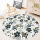 Round living room rug with blue and green floral pattern on an ivory background, placed in a cozy wooden interior with a rocking horse and storage cabinet.