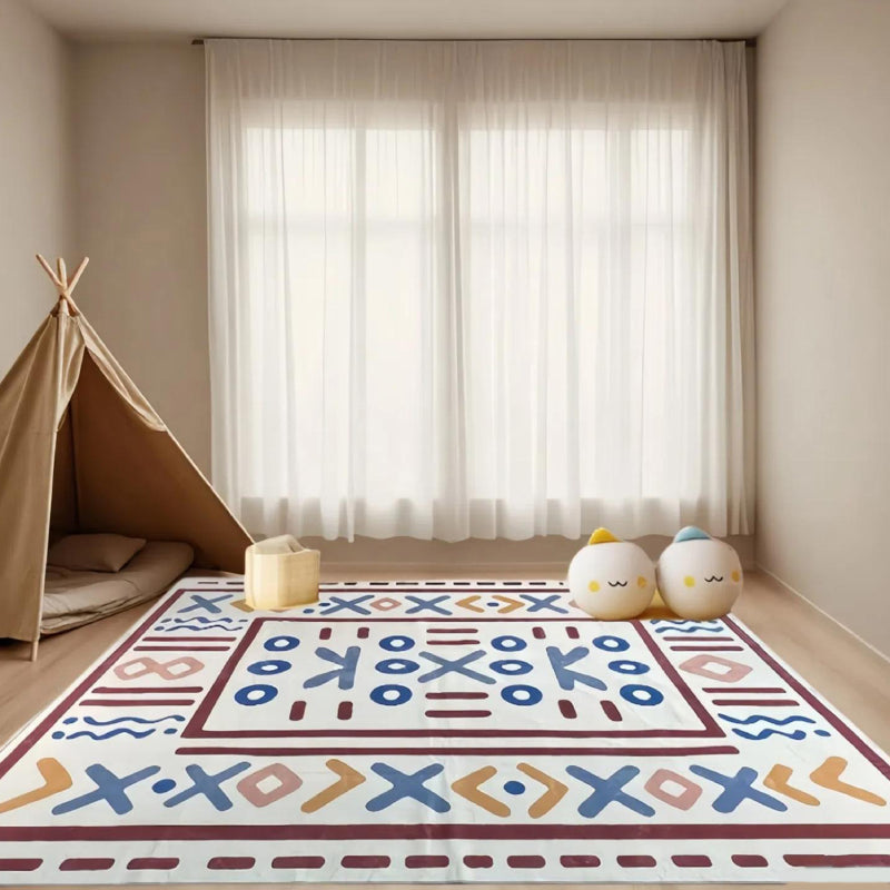 Geometric tribal-style rug with bold symbolic patterns laid in a bright, elegant living room setting.