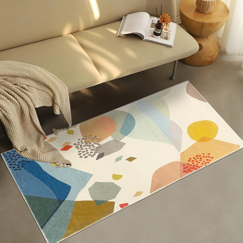 Kids rug with abstract colorful stone pattern in shades of blue, yellow, red, green, and beige on a cream background.