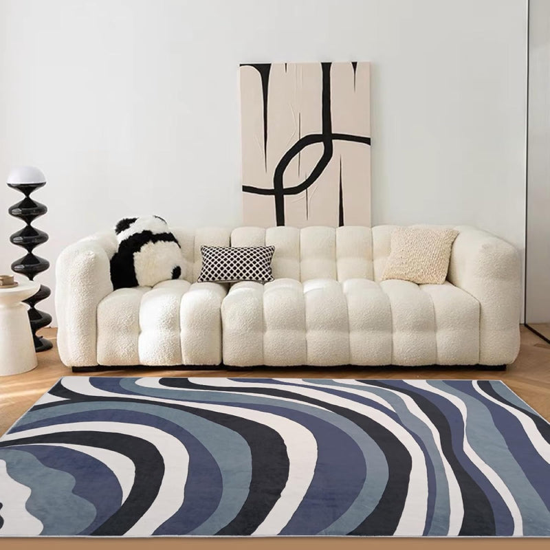 Laundry rug with abstract blue, black, and white wavy line pattern, modern design with a soft textured surface.