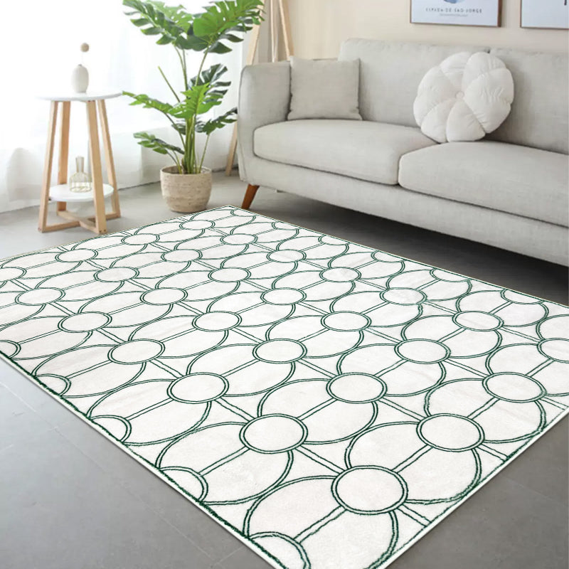White summer rug with a modern green circular geometric pattern.