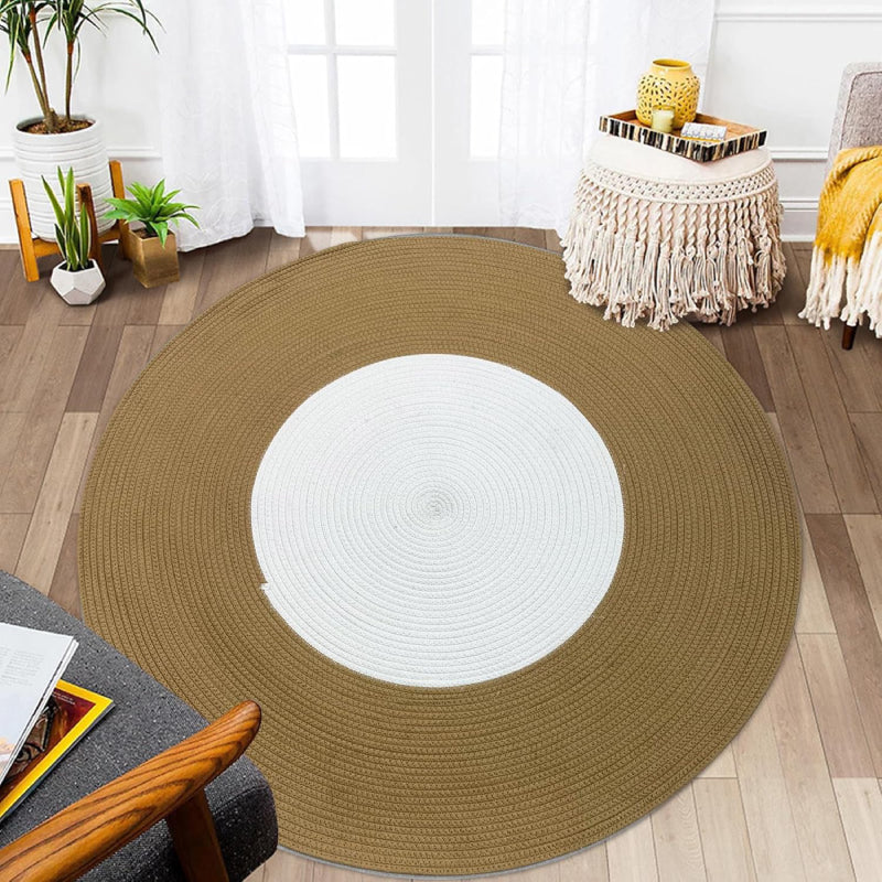 Round handmade braided rug with a white center and wide brown outer ring, made from cotton rope.