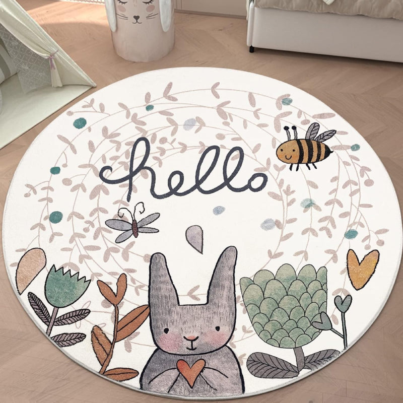Round children's rug featuring a cute gray Easter bunny holding a heart, surrounded by flowers, a bee, a butterfly, and the word "hello" in playful script on a light background.