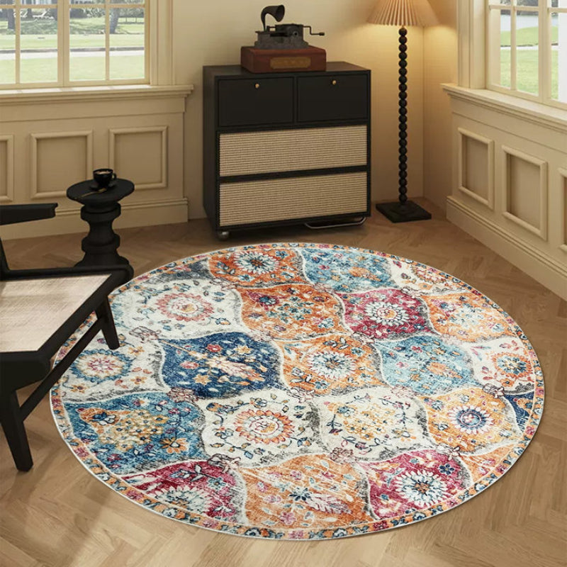 Round boho vintage area rug with a colorful patchwork of floral and medallion patterns in orange, blue, red, and cream tones.