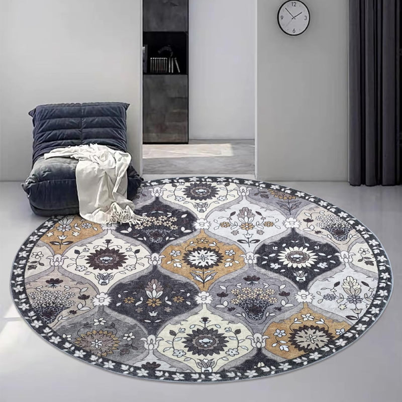 Round vintage floral rug with intricate medallion-style patterns in neutral tones of grey, ivory, and gold.