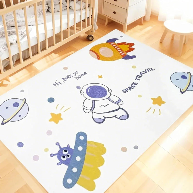 Kids rug with outer space theme featuring cartoon astronaut, rocket, UFO, planets, stars, and the phrases 'Hi, let's go home' and 'SPACE TRAVEL'.