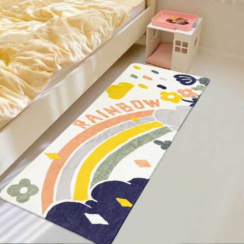 Colorful rectangular kids rug featuring a hand-drawn rainbow, clouds, raindrops, flowers, and the word "RAINBOW" in playful letters, placed in a cozy playroom setting.