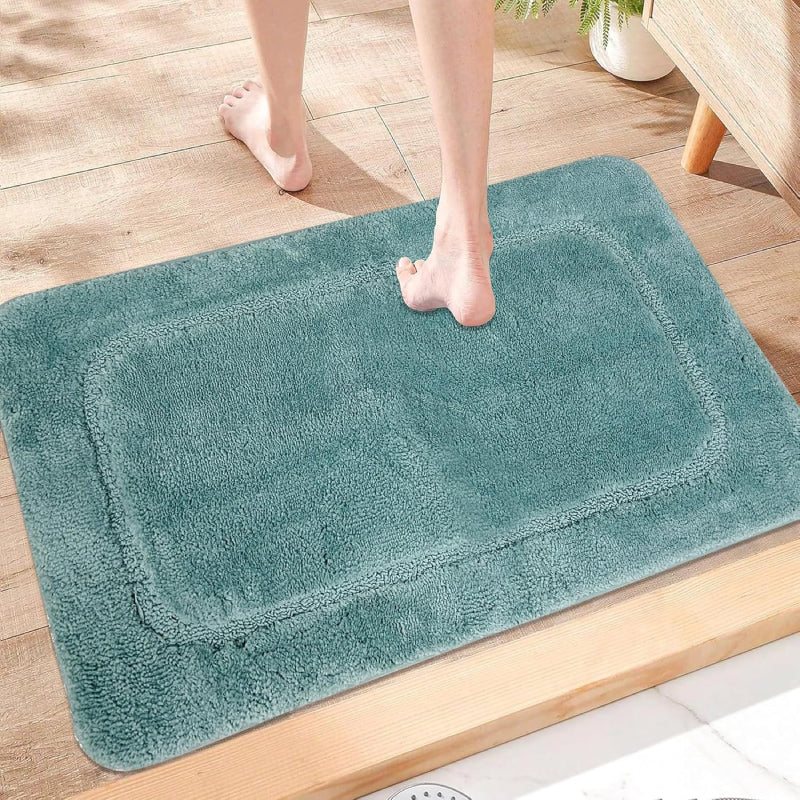 Turquoise shaggy bathroom rug with soft microfiber texture and simple rectangular border design, perfect for a cozy, spa-like feel.