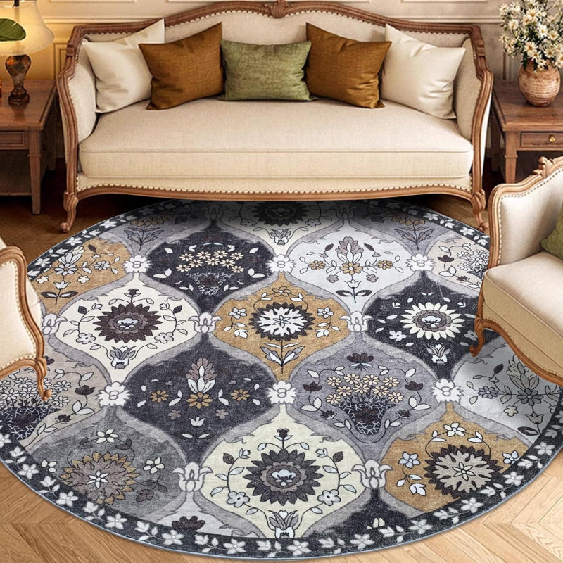 Round vintage floral rug with intricate medallion-style patterns in neutral tones of grey, ivory, and gold.