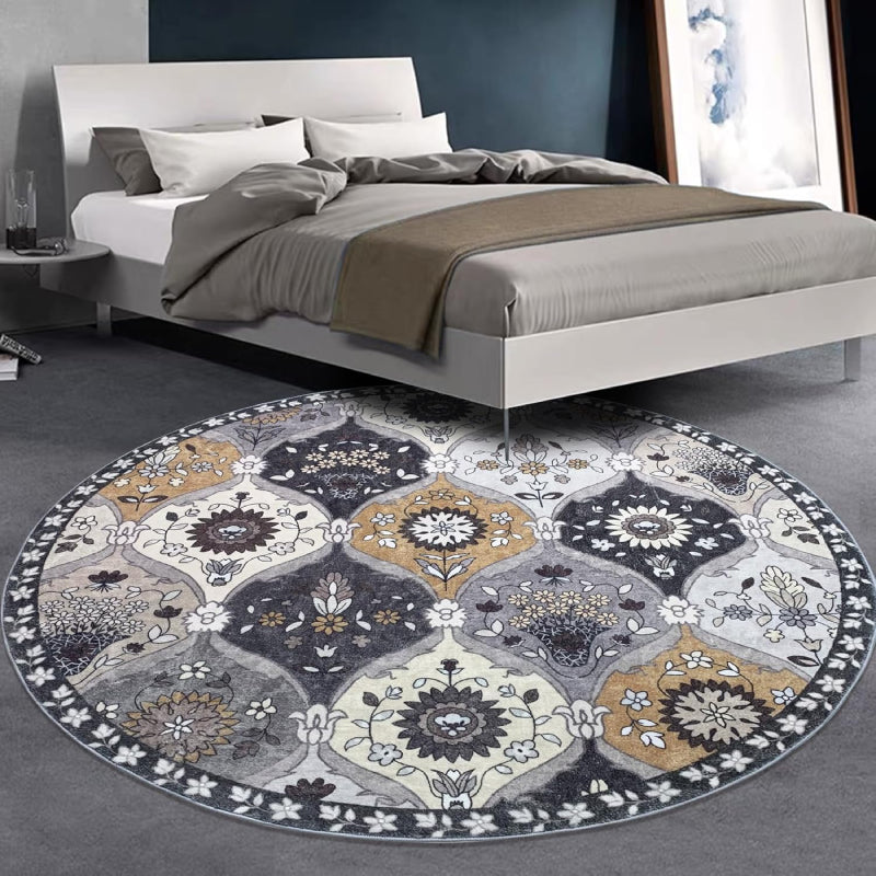 Round vintage floral rug with intricate medallion-style patterns in neutral tones of grey, ivory, and gold.